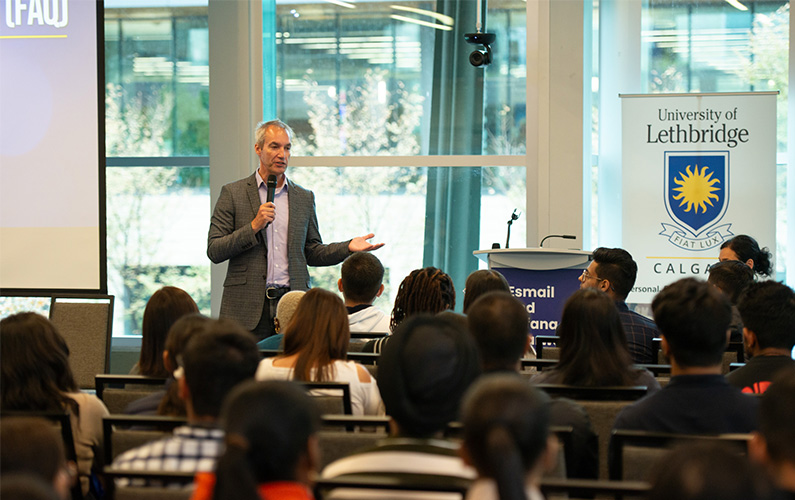 A person conducting orientation to a group of new students.