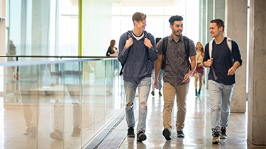 Three students walking down the hallway.