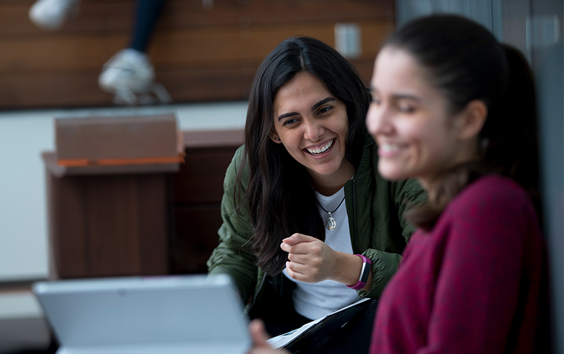 An international student with an advisors reviewing information on a laptop