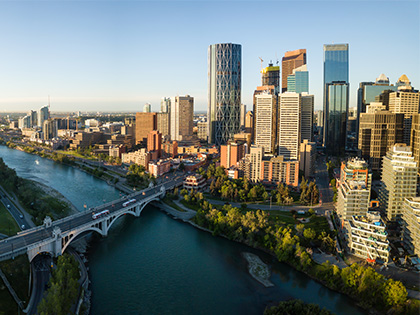 A river, bridge and buildings in the background in Calgary