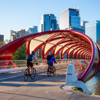 Photo of two people riding bicycles across the Peace Bridge in Calgary